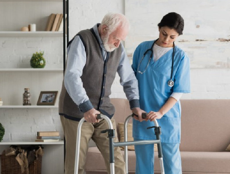 caregiver assisting elder woman on using a walker